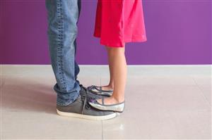 Girl standing on daddys' shoes